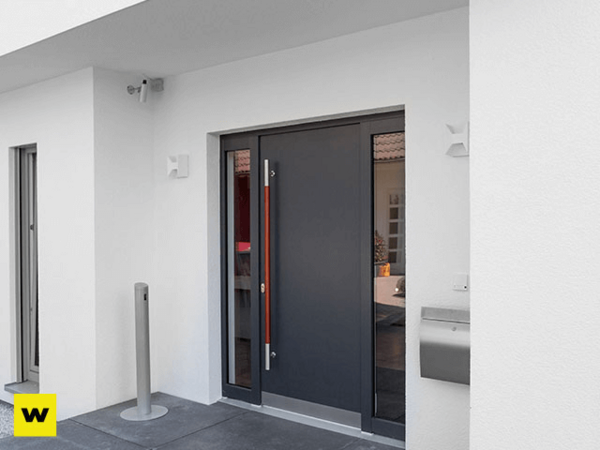 Moderne Haustür aus Aluminium mit Seitenteil, Briefkasten und Videoüberwachung am Eingang.